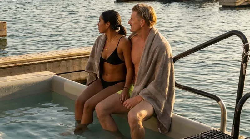 Two guests at the edge of the cold plunge, about to lower themselves in